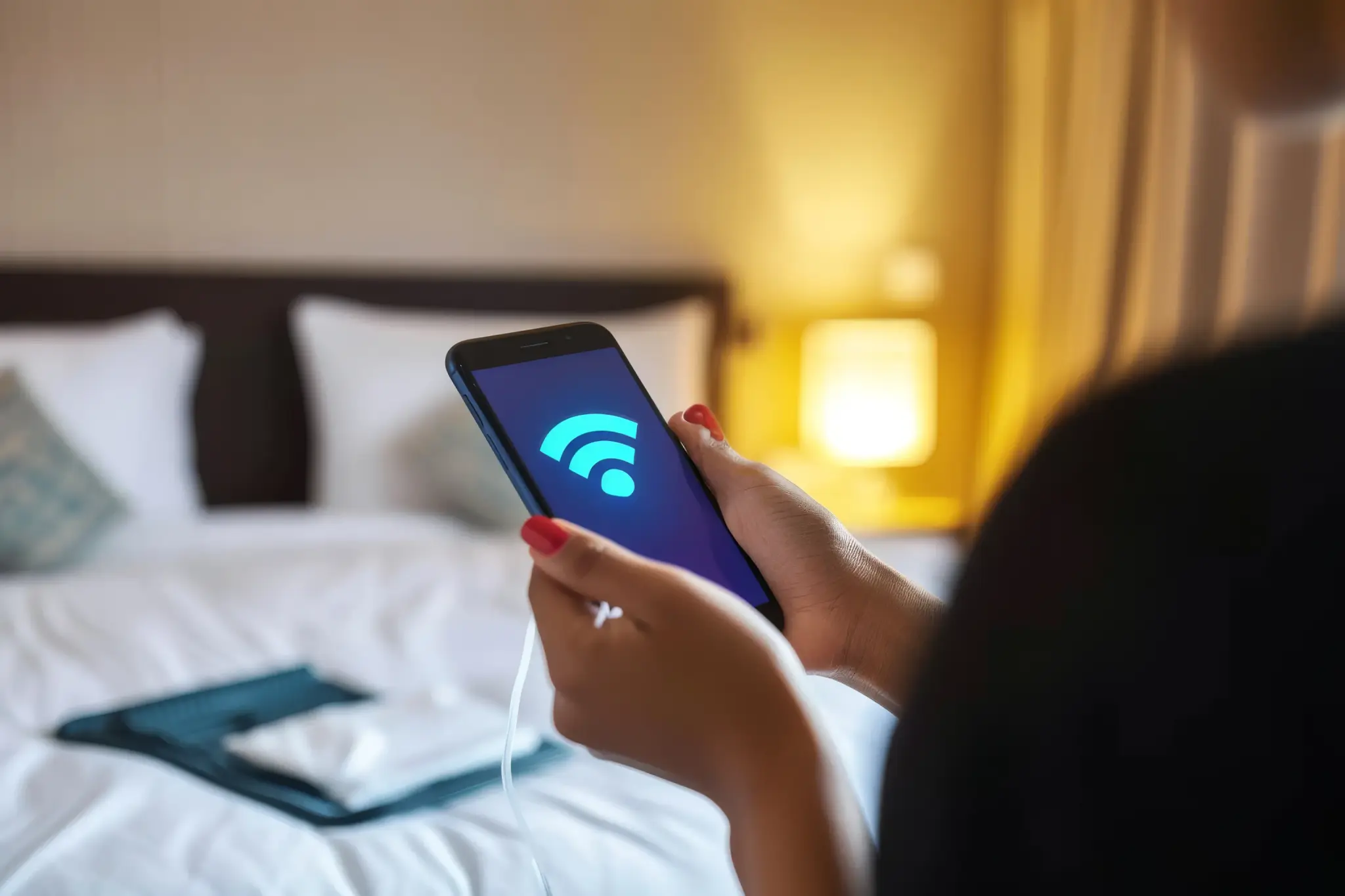 Guest gaining wifi access on smartphone in a comfortable hotel room